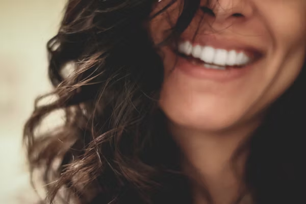 a blurry image of a woman smiling widely